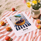 Plum – White village Urban Café Scene, Fruit Wall Illustration, unframed on coastal sand